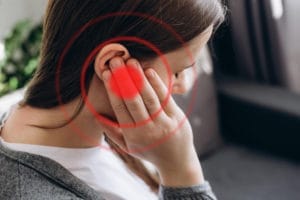 woman holding her ear in pain, highlight by red circles