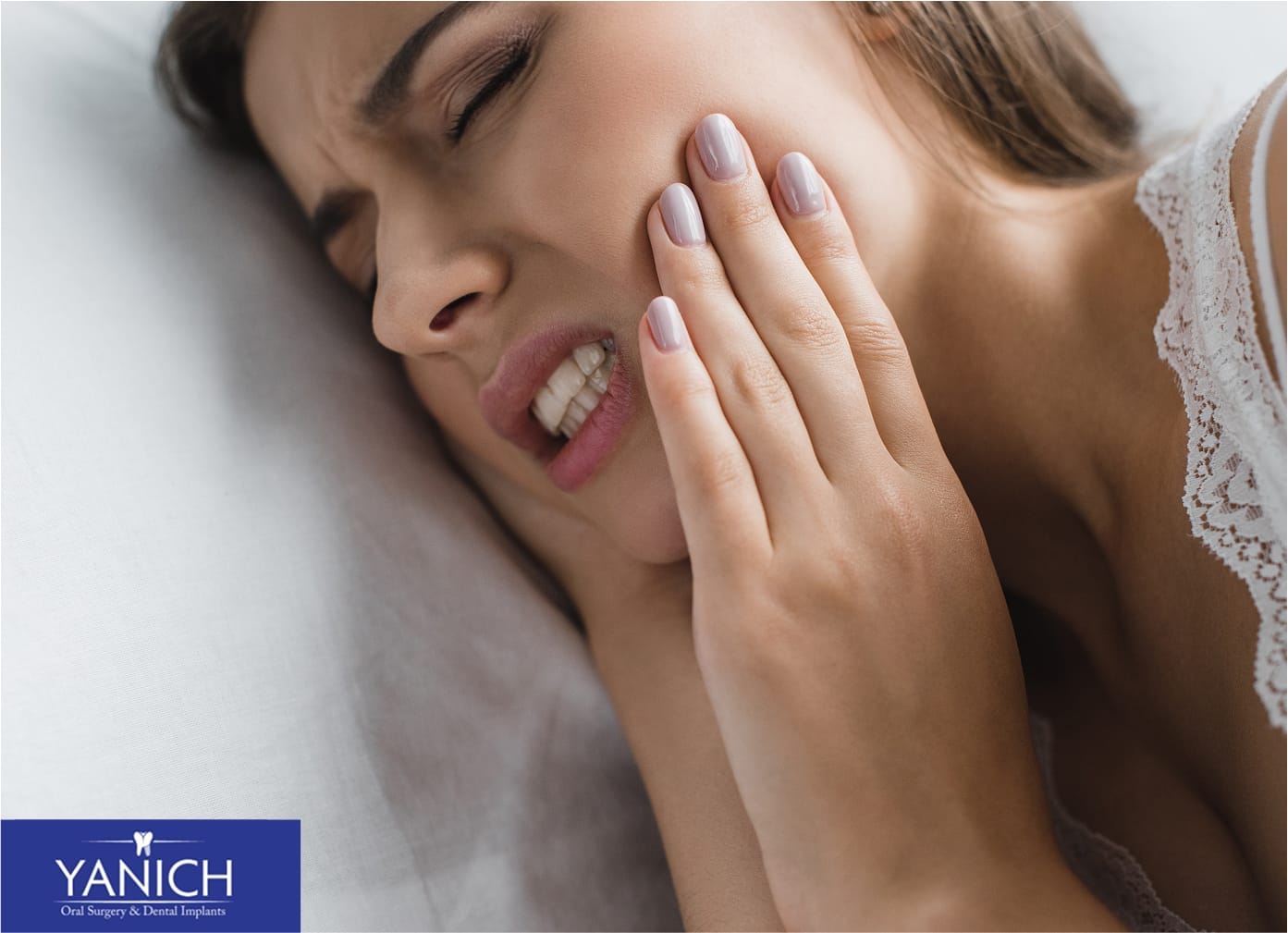 Woman experiencing wisdom tooth pain holding her jaw