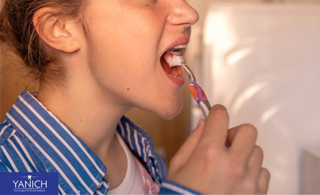 A person brushing their teeth with a manual toothbrush, demonstrating proper oral hygiene techniques for maintaining healthy gums and clean teeth.